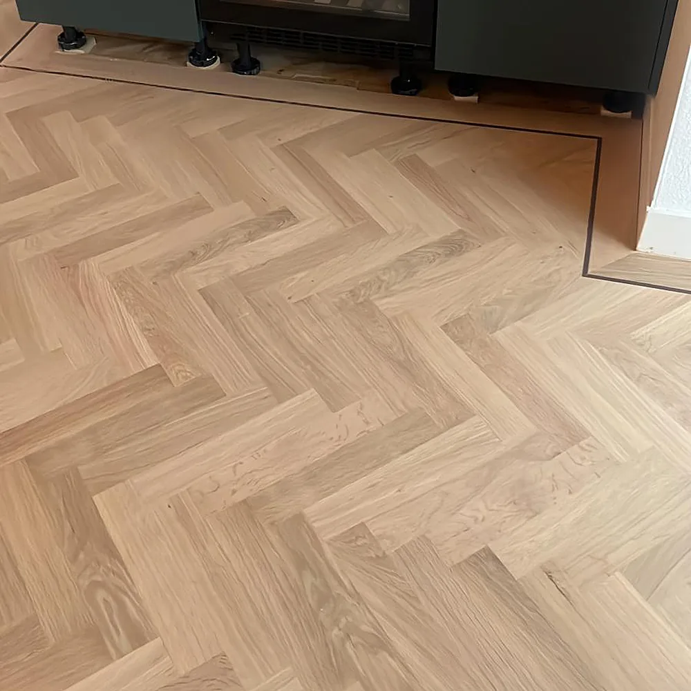 Lichte eiken visgraat parketvloer in moderne keuken